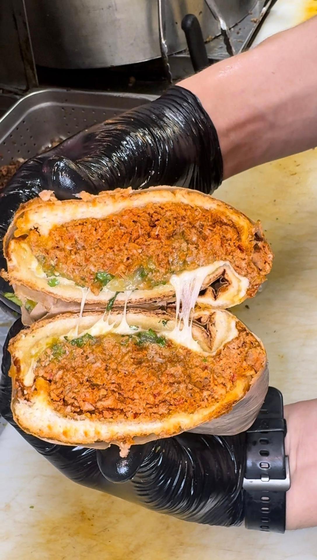 Torta mexicana con bolillo cargado y queso fundido en Tacos El Viejon